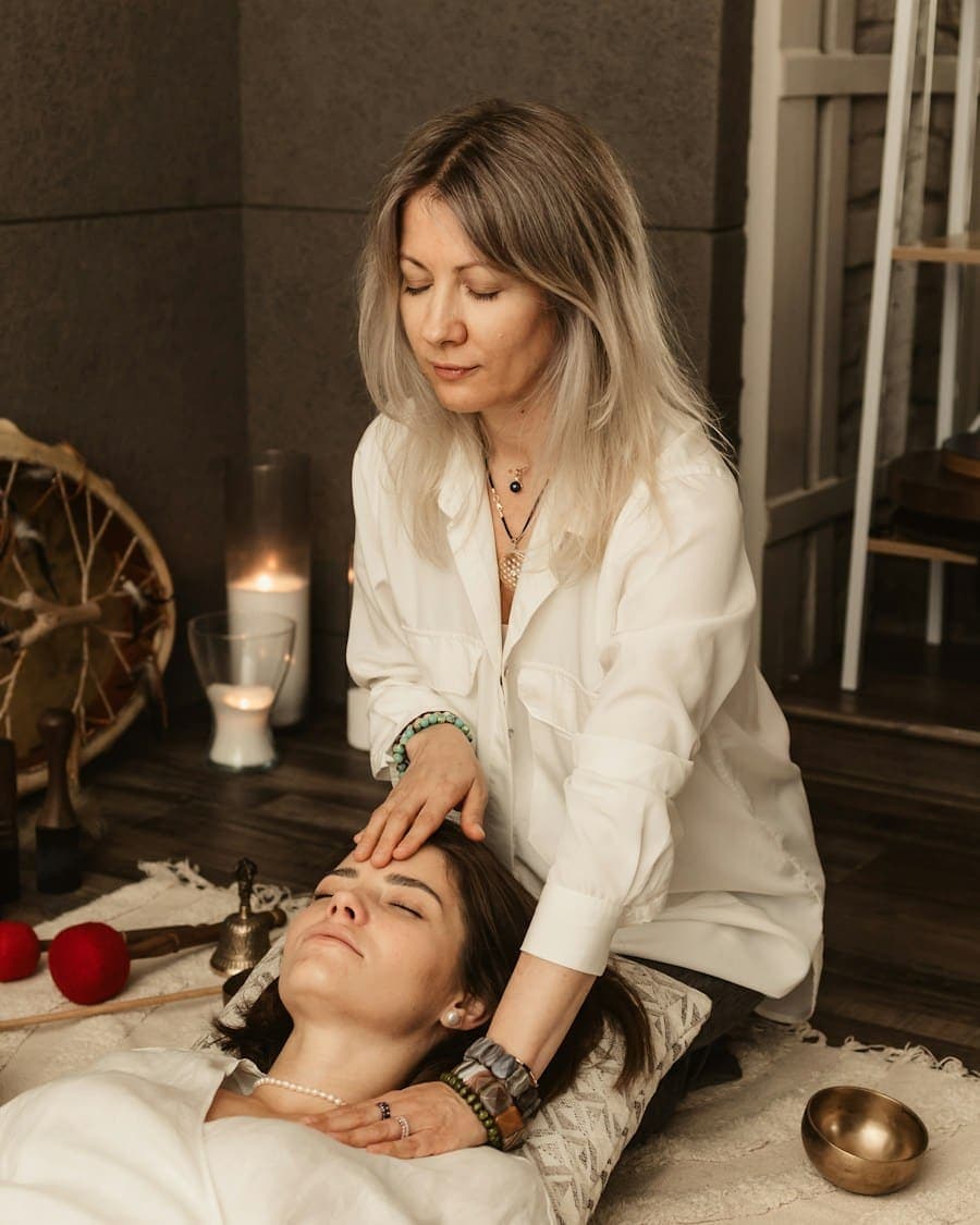 Terapeuta apoyando las manos sobre la frente de una mujer recostada